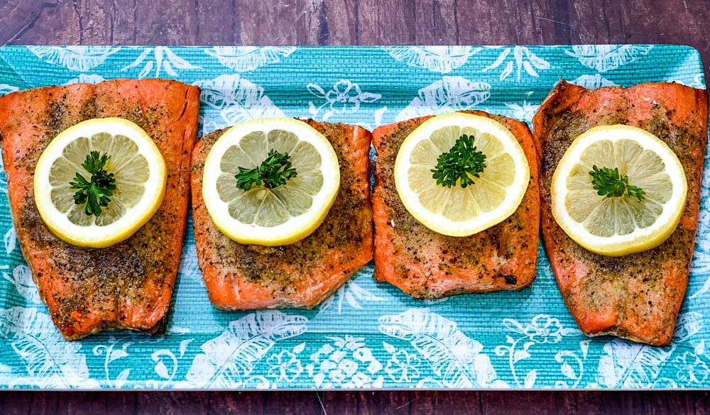 air fryer salmon on a blue plate with a fresh lemon size