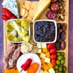 charcuterie board with artichokes, fig spread, cheese, and meat