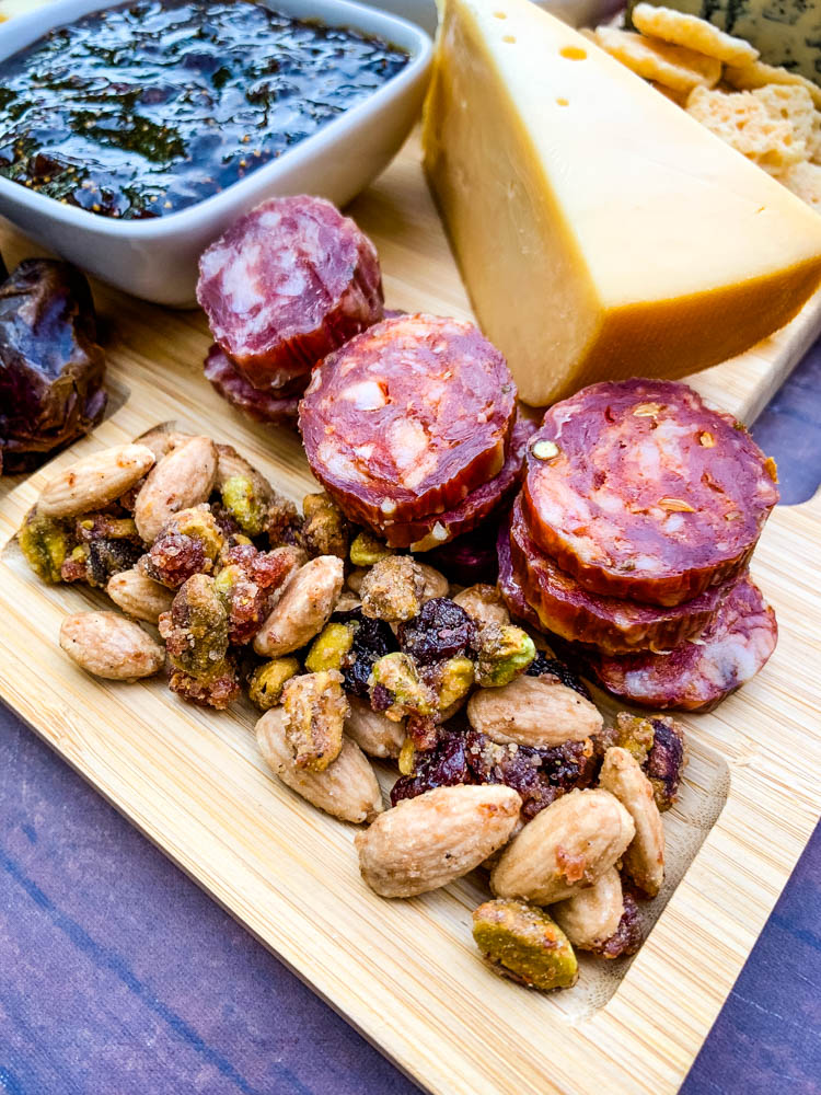 charcuterie board with artichokes, fig spread, cheese, and meat