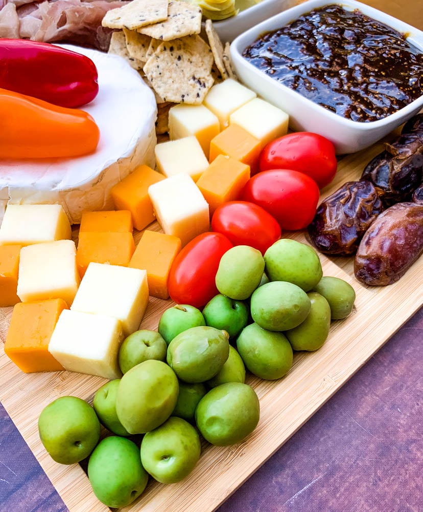 charcuterie board with artichokes, fig spread, cheese, and meat