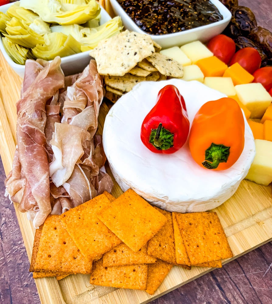 charcuterie board with artichokes, fig spread, cheese, and meat