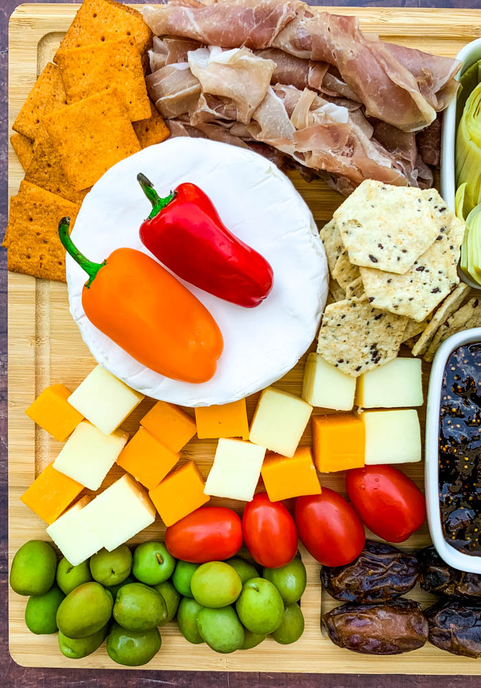 charcuterie board with artichokes, fig spread, cheese, and meat