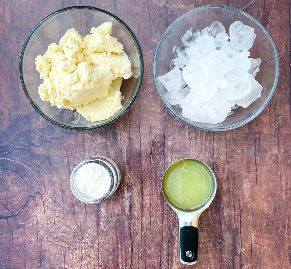 vanilla ice cream, ice cubes, confectioner's sweetener, and fresh lemon juice in a glass bowl