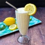 chickfila frosted lemonade in a glass cup garnished with a lemon and straw