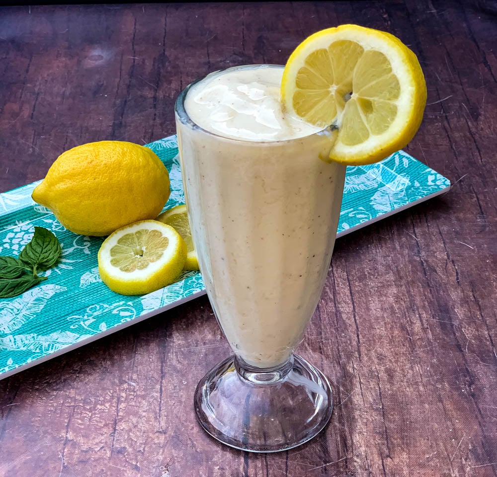 chickfila frosted lemonade in a glass cup garnished with a lemon and straw