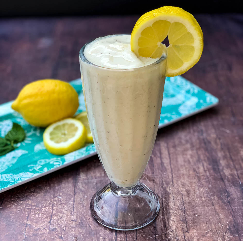 chickfila frosted lemonade in a glass cup garnished with a lemon and straw