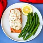 crab stuffed salmon on a white plate with green beans