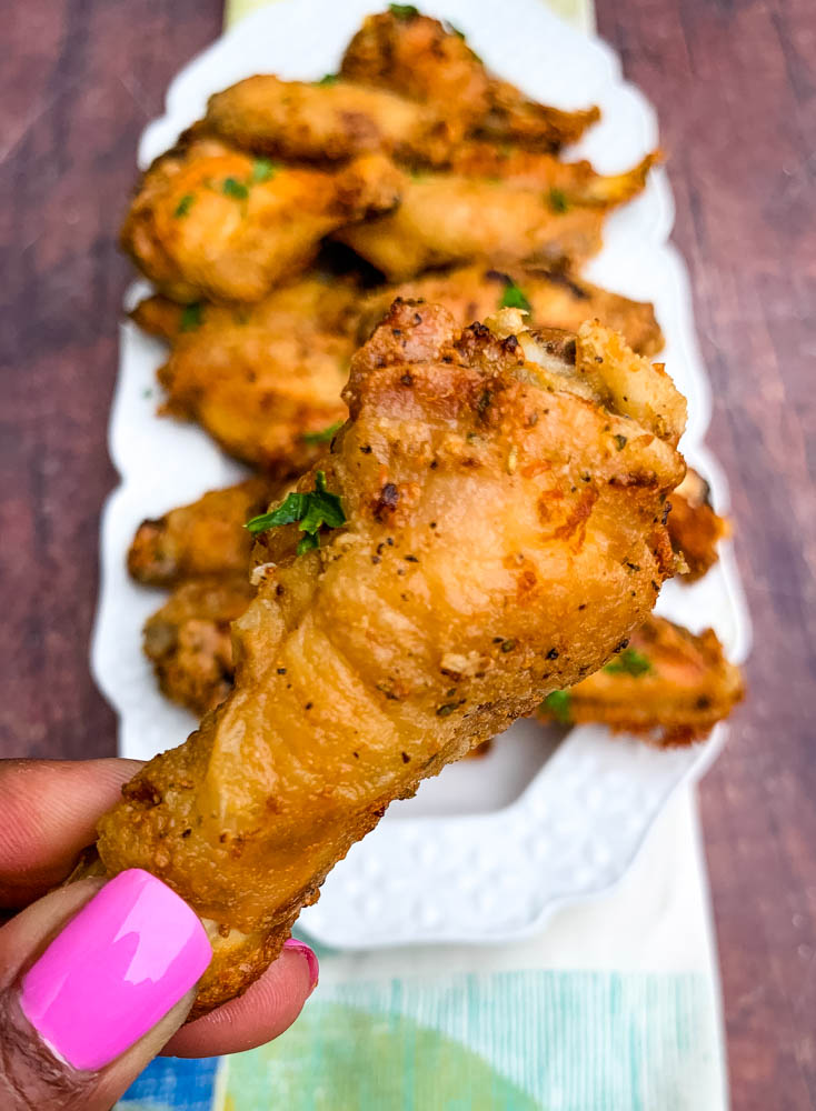 person holding air fryer keto fried chicken wings
