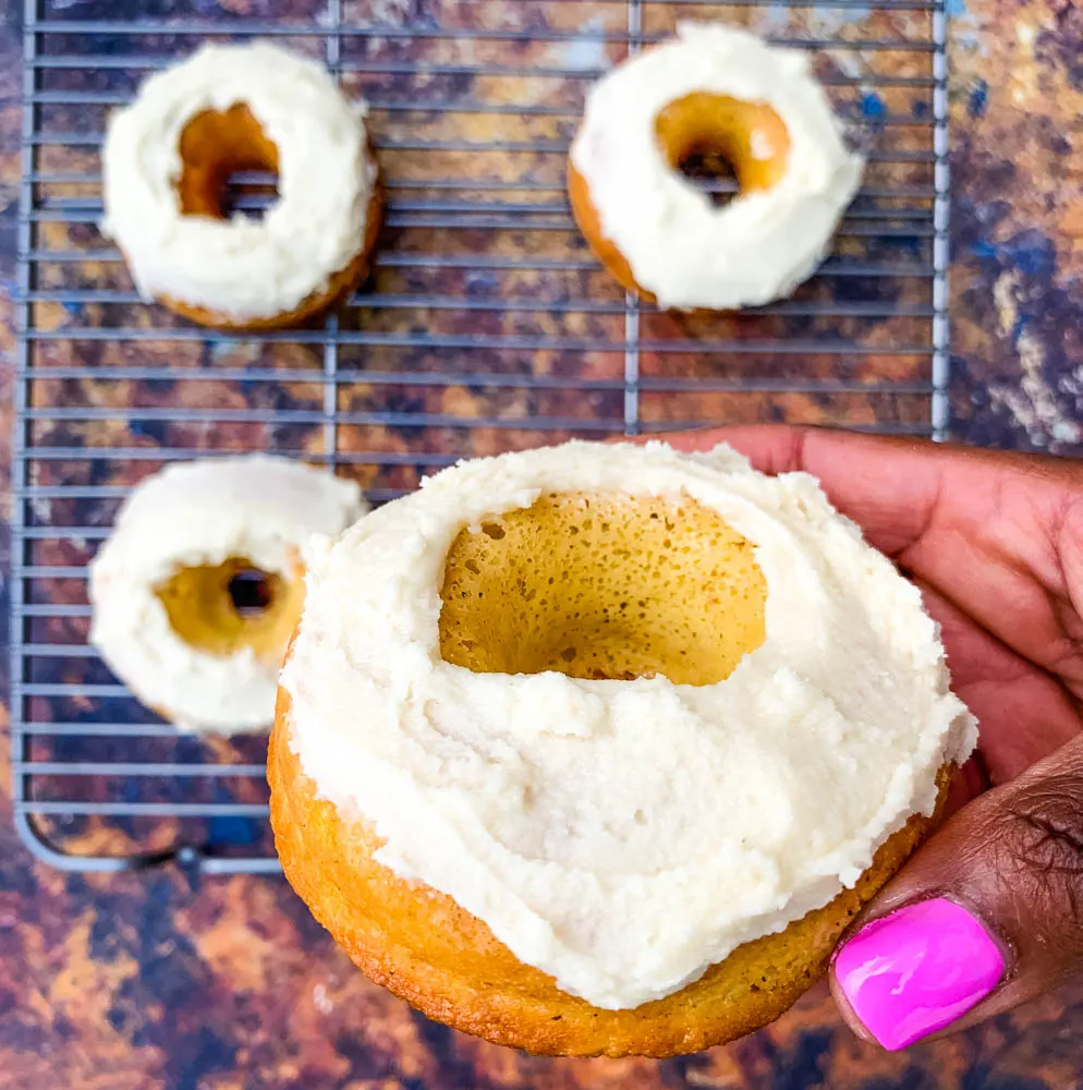 person holding keto low carb donuts with frosted glaze