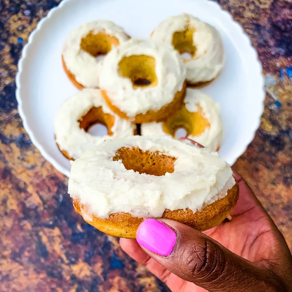 person holding keto low carb donuts with frosted glaze