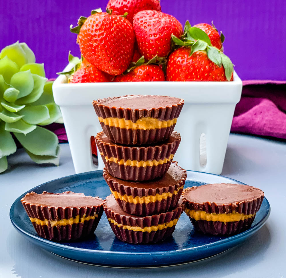 keto peanut butter cups on a blue plate with strawberries