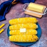 air fryer corn on the cob on a blue plate with butter