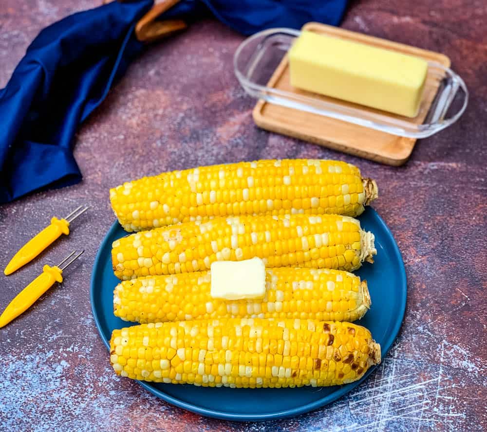 air fryer corn on the cob on a blue plate with butter