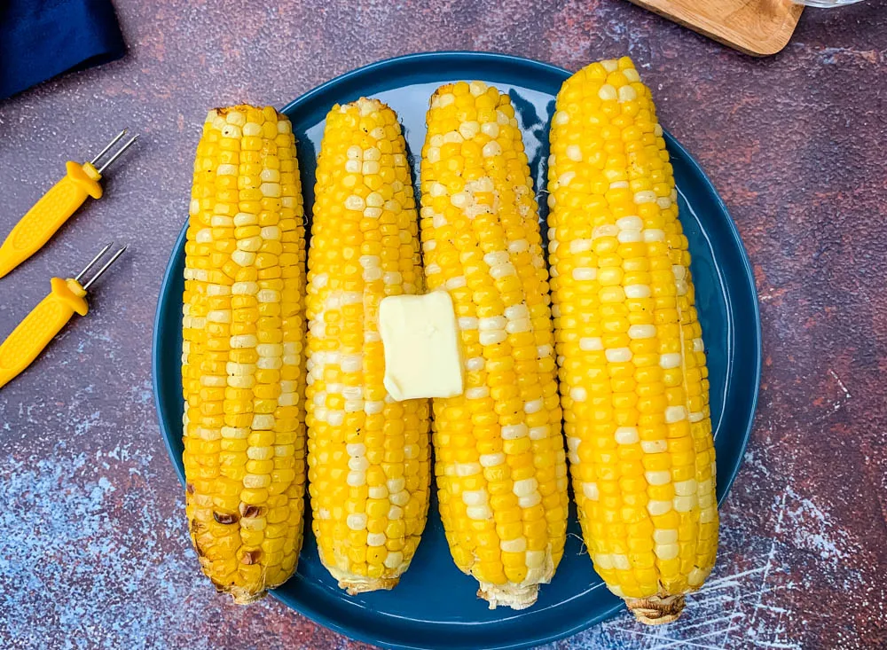 air fryer corn on the cob on a blue plate with butter