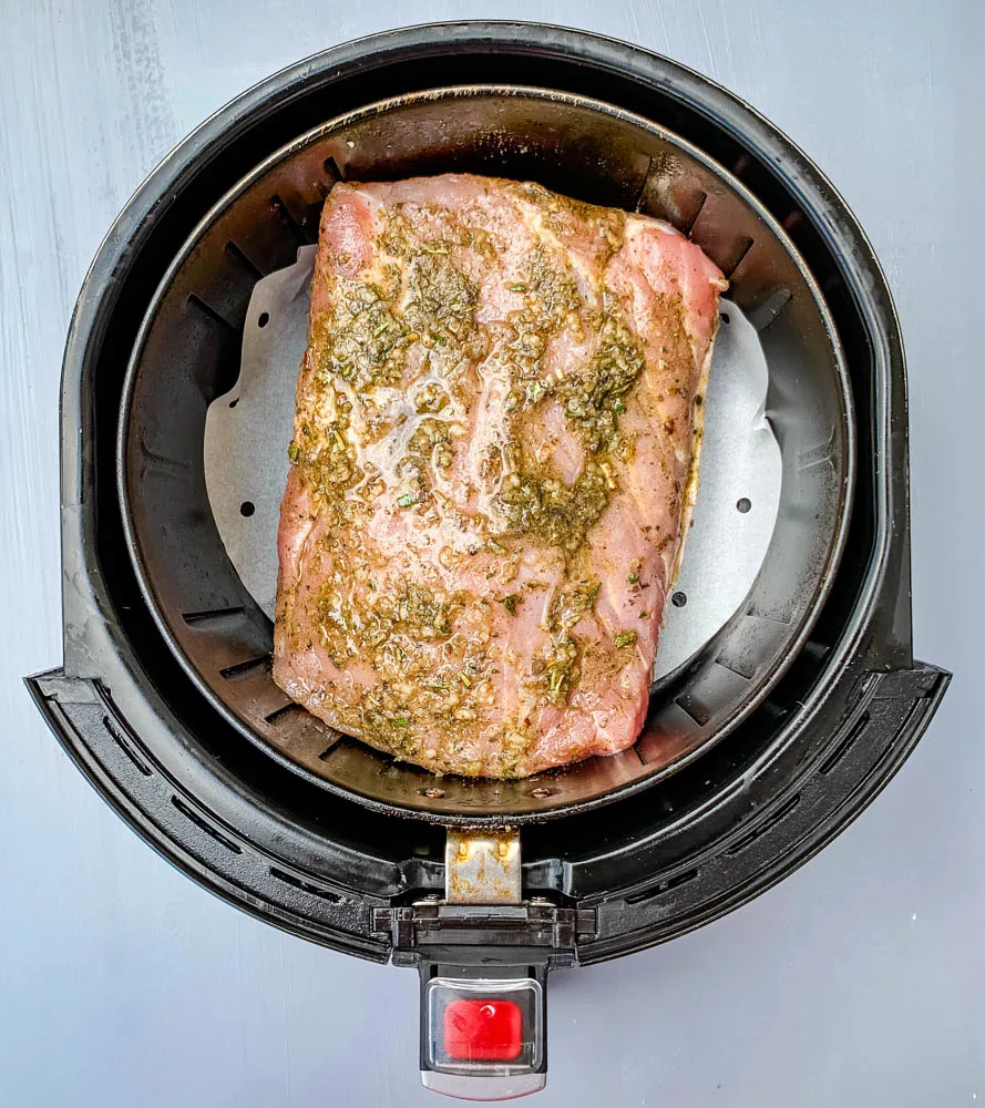 raw air fryer pork loin in an air fryer basket