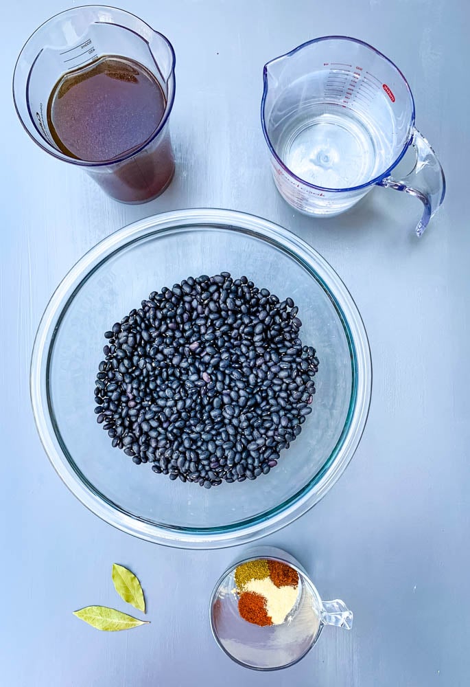 rinsed black beans, 2 cups of water, 2 cups broth, and seasonings in a glass