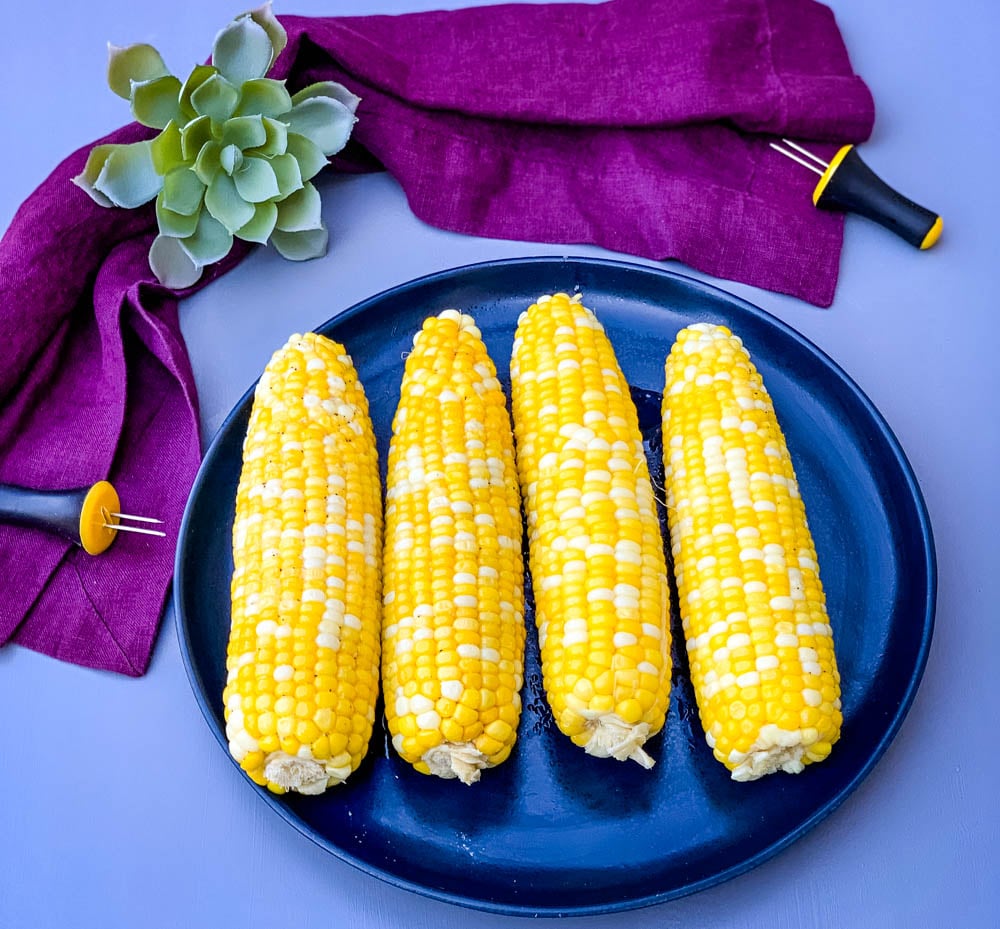 instant pot corn on the cob on a blue plate with a purple napkin
