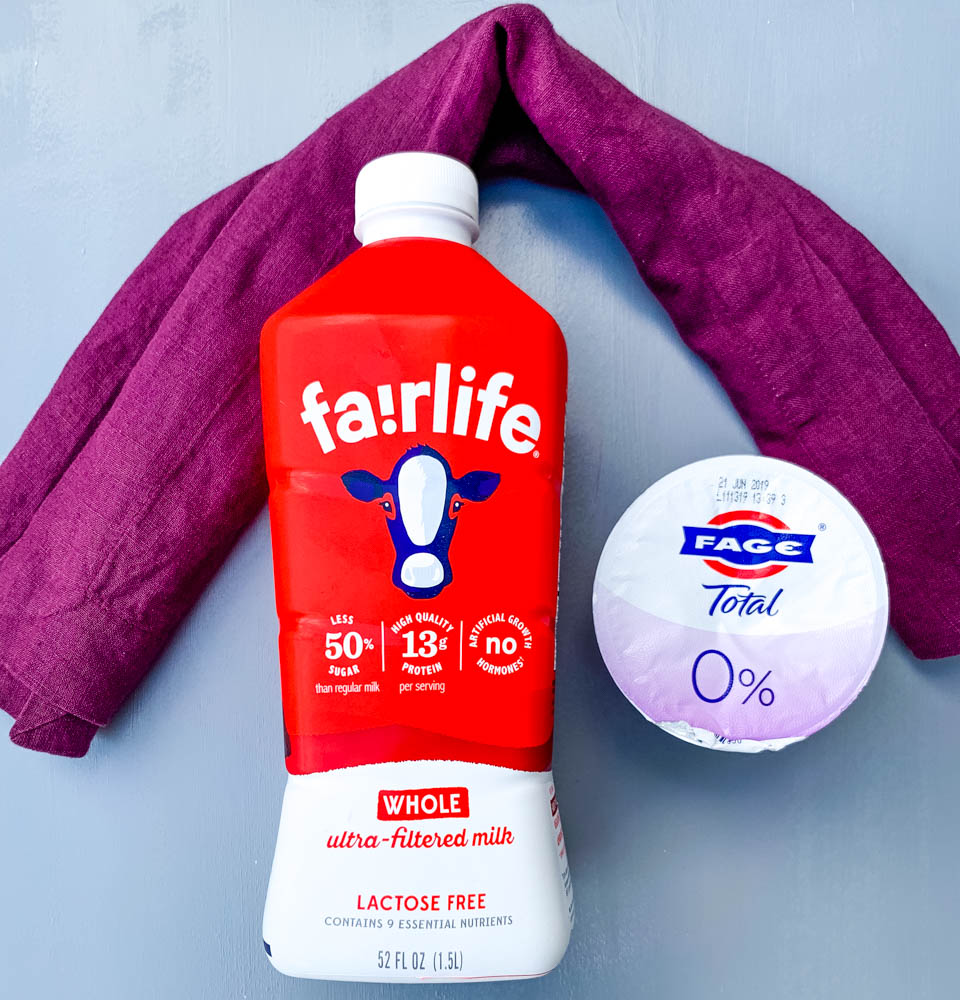 fairlife milk and fage yogurt on a blue flat surface