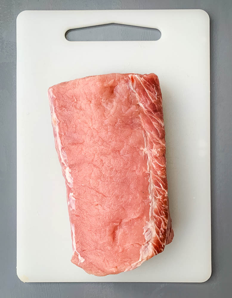 raw pork loin roast on a cutting board