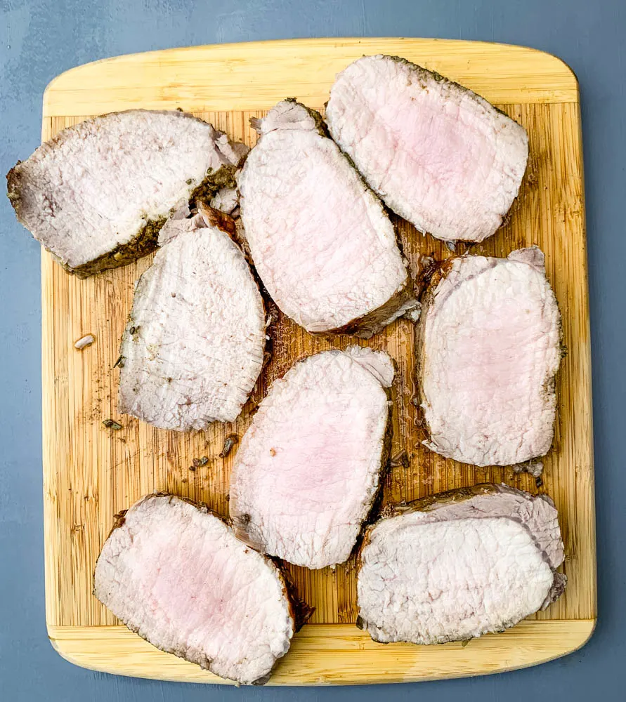 cooked sliced Instant Pot pork loin on a cutting board