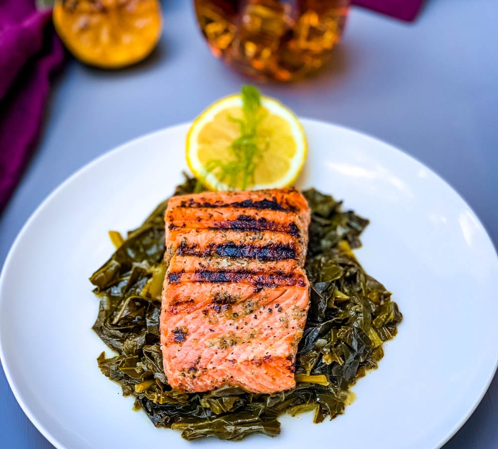 pan seared cast iron salmon on a white plate with greens