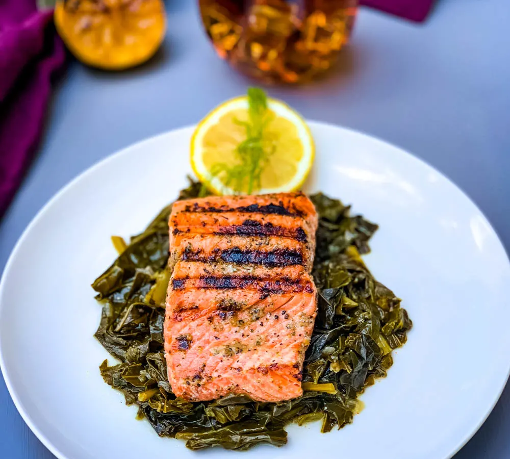 pan seared cast iron salmon on a white plate with greens