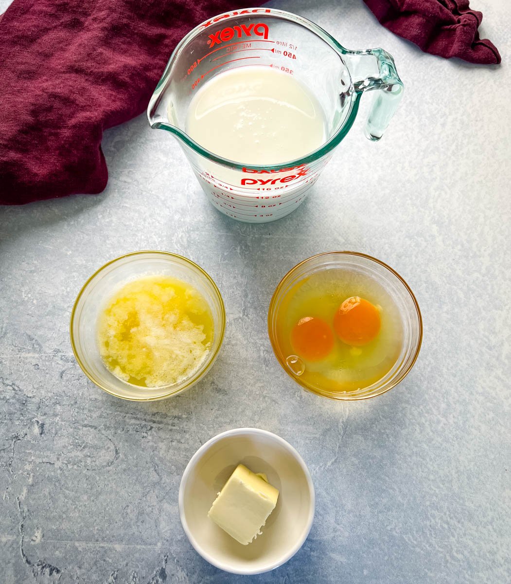 eggs, buttermilk, cormeal mix, sugar, and a stick of butter on a flat surface