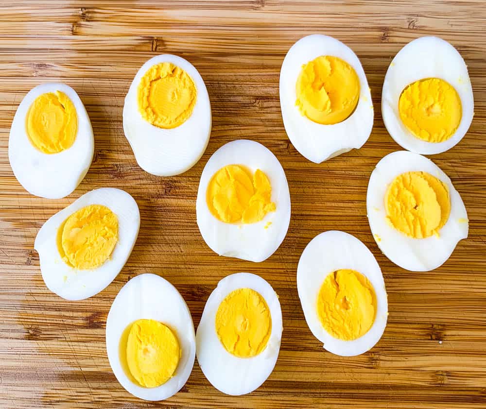 air fryer hard boiled eggs sliced on a bamboo cutting board