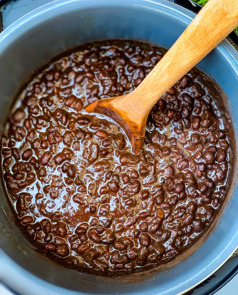 black bean soup in an Instant Pot with a wooden spoon