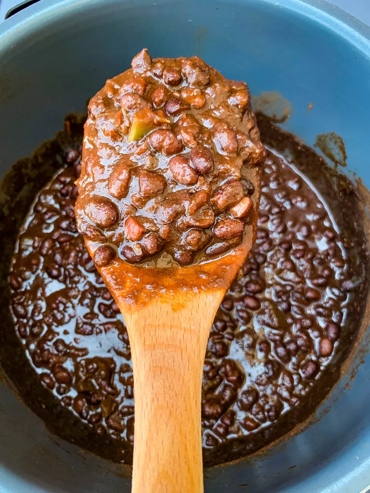 a wooden spoon filled with Instant Pot black bean soup