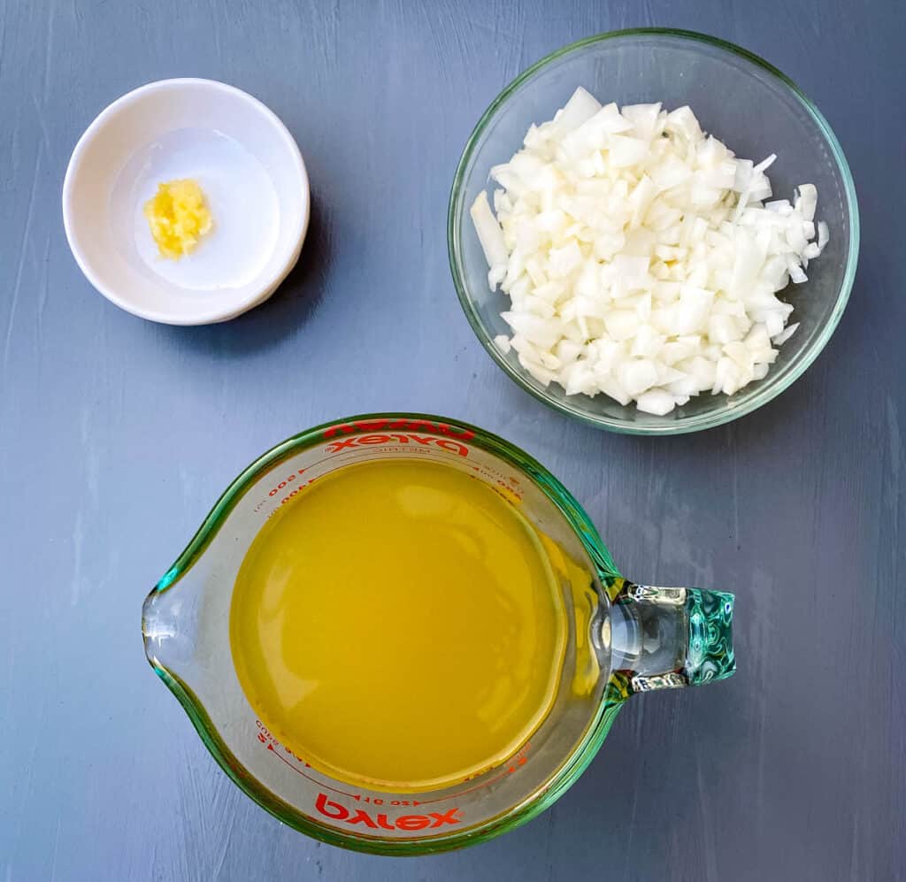 chicken broth, garlic, and onions in separate bowls