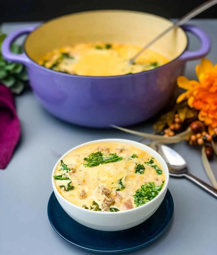 keto low carb zuppa toscana soup in a purple cast iron Dutch oven with a bowl of soup in a white bowl