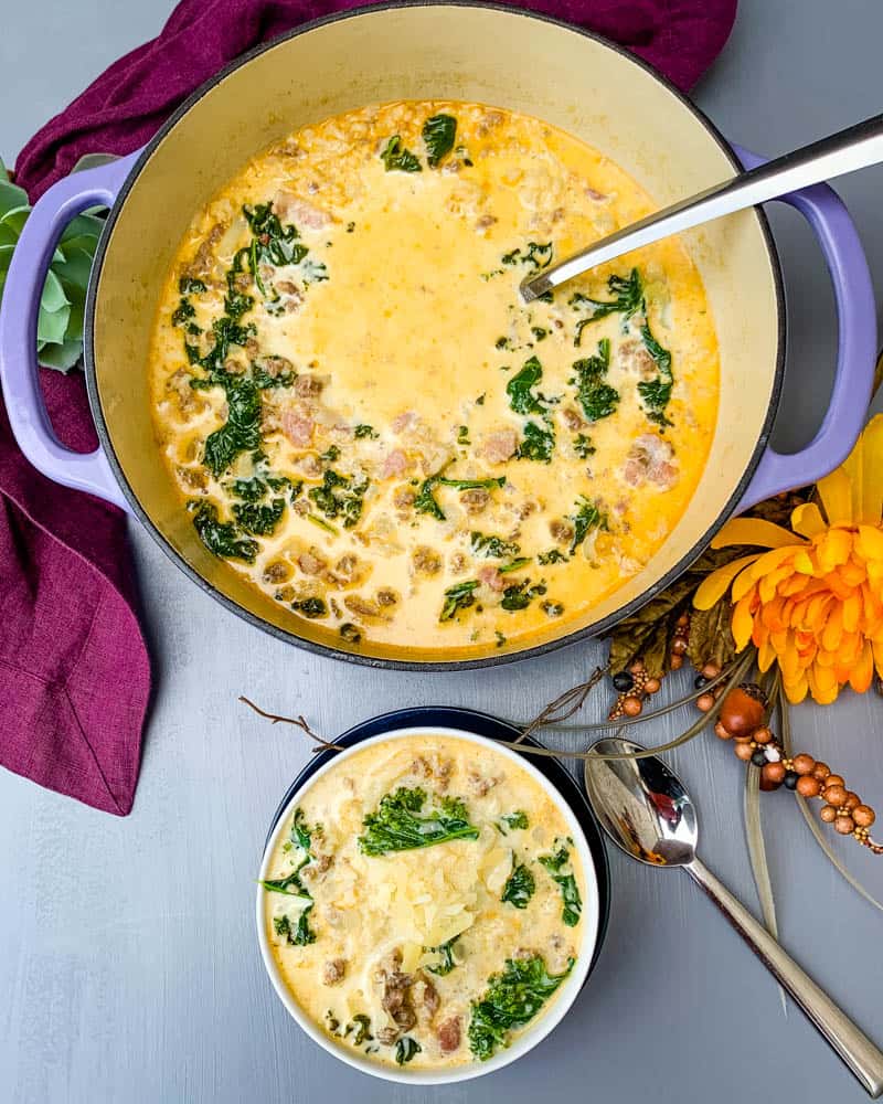 keto low carb zuppa toscana soup in a purple cast iron Dutch oven with a bowl of soup in a white bowl