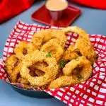 air fryer crispy onion rings in a bowl with a red wrapper