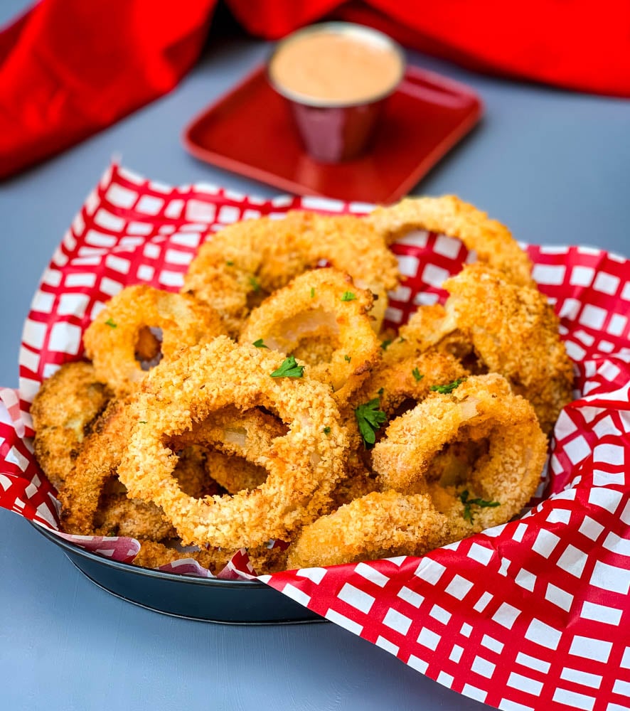 air fryer crispy onion rings in a bowl with a red wrapper