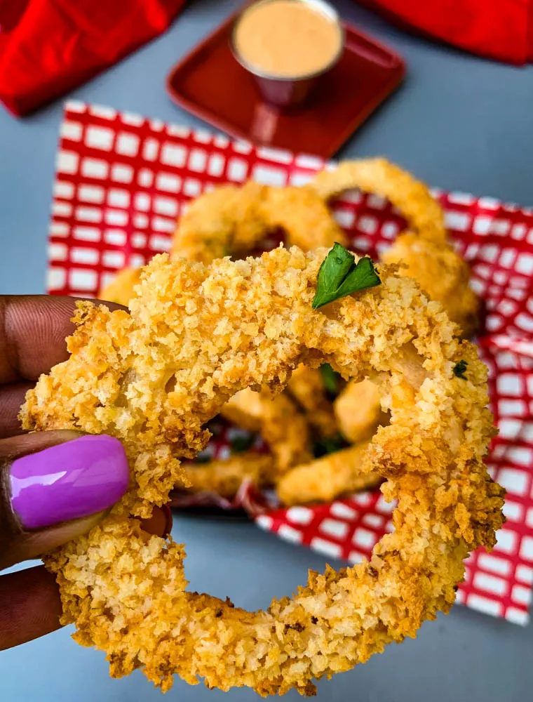 person holding air fryer onion ring