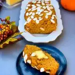 keto low carb pumpkin bread on a white plate with a slice of pumpkin bread on a blue plate