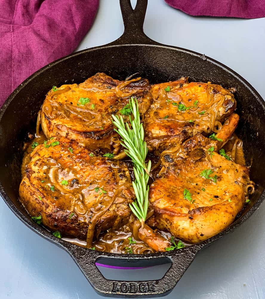 keto low carb smothered pork chops in a cast iron skillet