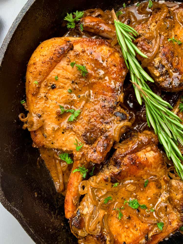 keto low carb smothered pork chops in a cast iron skillet