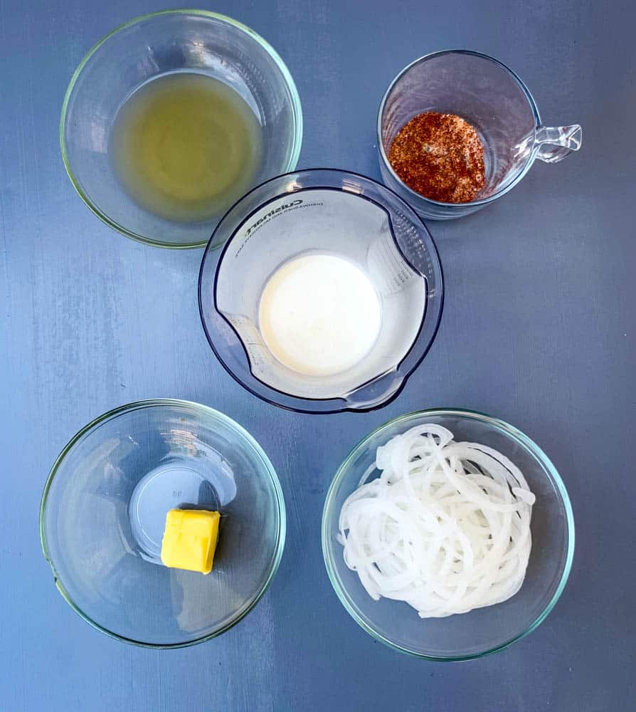 panna, brodo di pollo, cipolle, condimento, e il burro in ciotole di vetro