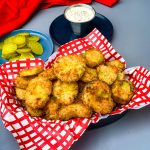 air fryer crunchy fried pickles in a basket with a side of ranch dressing