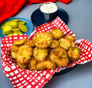 air fryer crunchy fried pickles in a basket with a side of ranch dressing