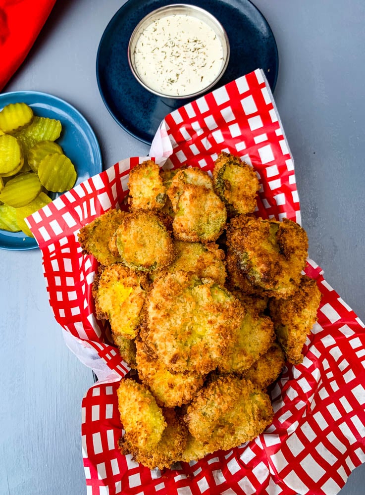 air fryer crunchy fried pickles in a basket with a side of ranch dressing