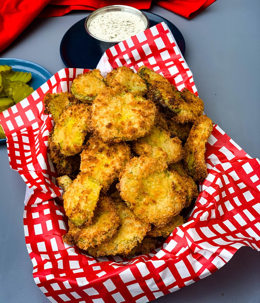 air fryer crunchy fried pickles in a basket with a side of ranch dressing