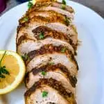 air fryer roasted turkey breast on a white plate with sliced lemon