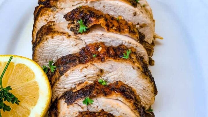 air fryer roasted turkey breast on a white plate with sliced lemon