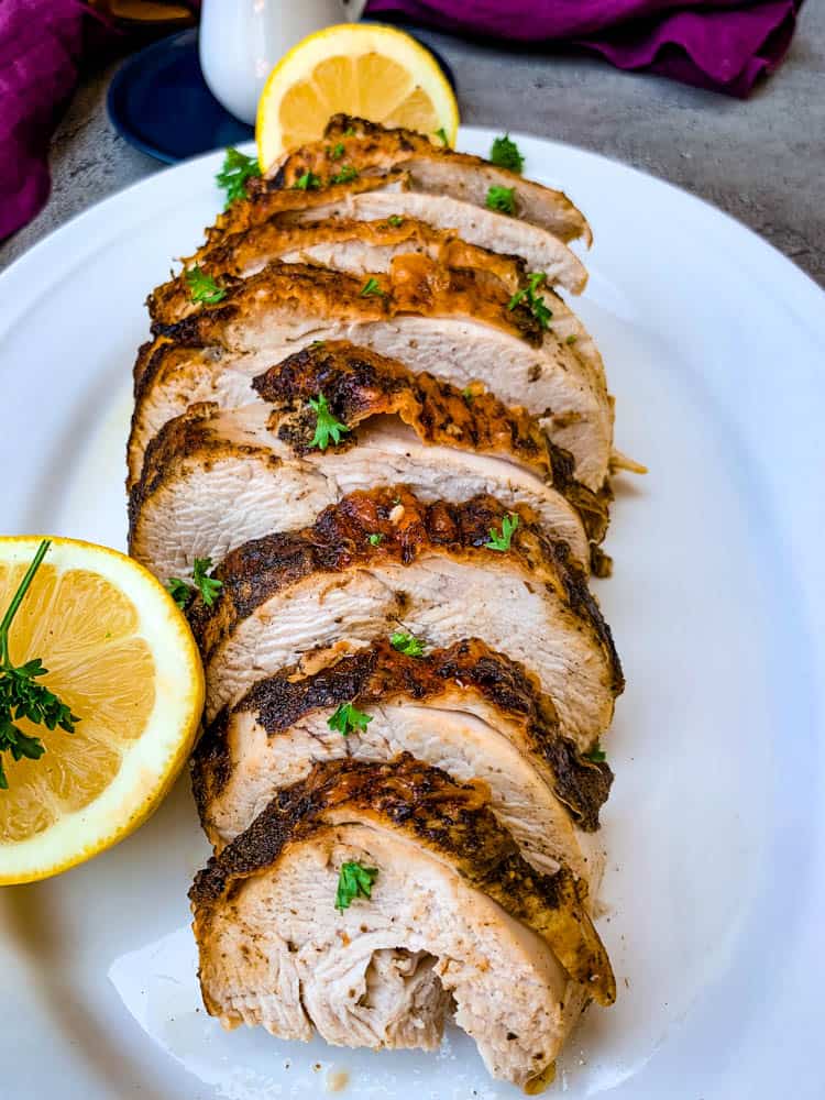 air fryer roasted turkey breast on a white plate with sliced lemon