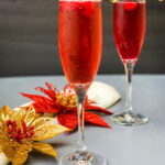 cranberry champagne mimosa in a glass with fresh cranberries