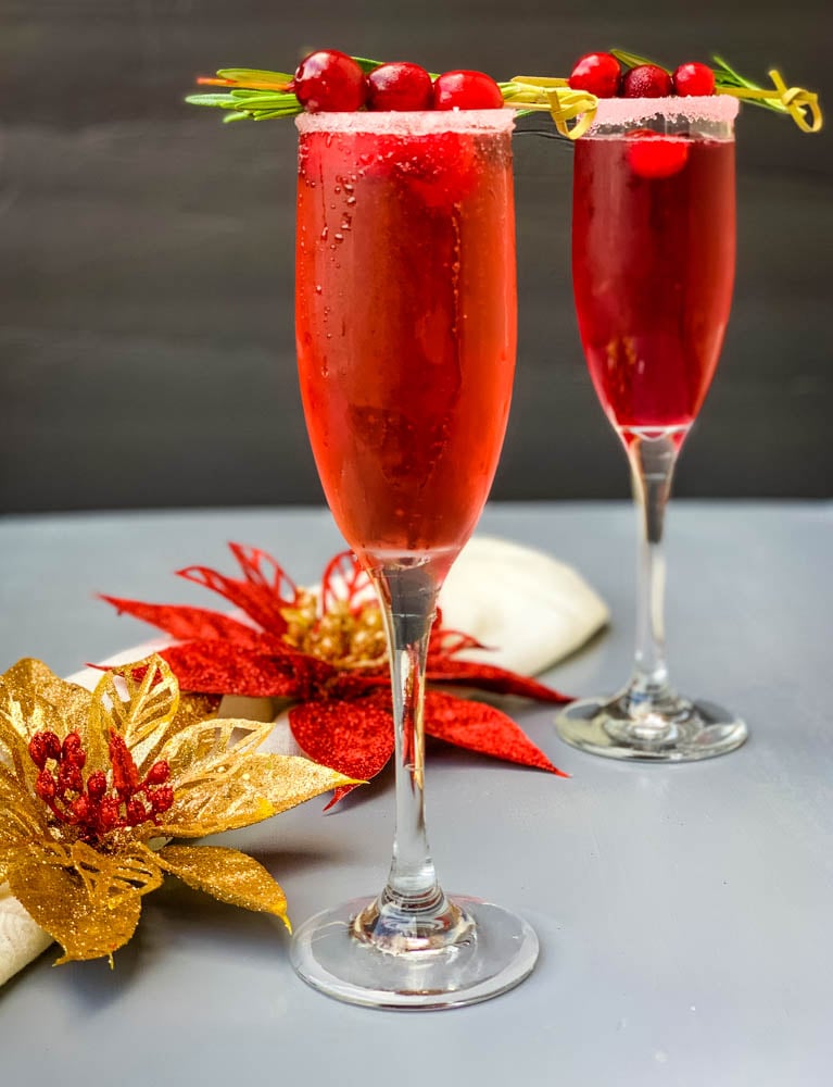 cranberry champagne mimosa in a glass with fresh cranberries