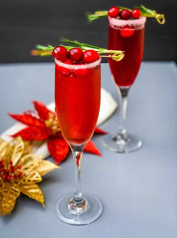 cranberry champagne mimosa in a glass with fresh cranberries